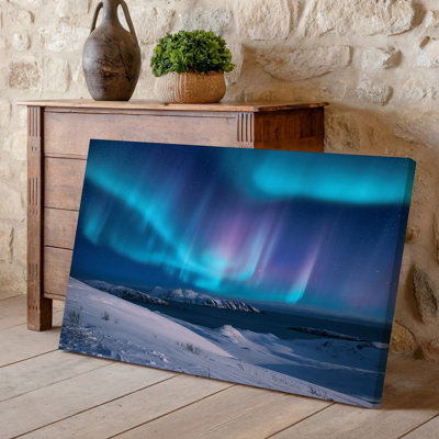 Toile, "Un paysage d'hiver à couper le souffle illuminé par une aurore boréale vibrante", mettant en vedette des nuances tourbillonnantes de mauve sarcelle et toile