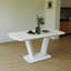 Table de salle à manger extensible blanche avec pieds élégants en forme de U pour une maison moderne