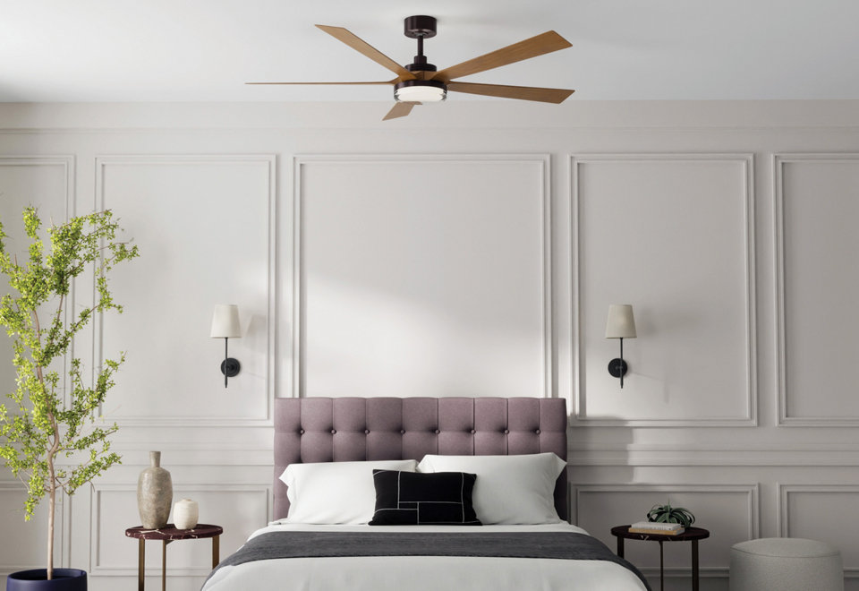 Modern bedroom featuring a contemporary dark brown ceiling fan with wood blades and integrated lighting, centered above a tufted mauve headboard and elegant white paneled walls.
