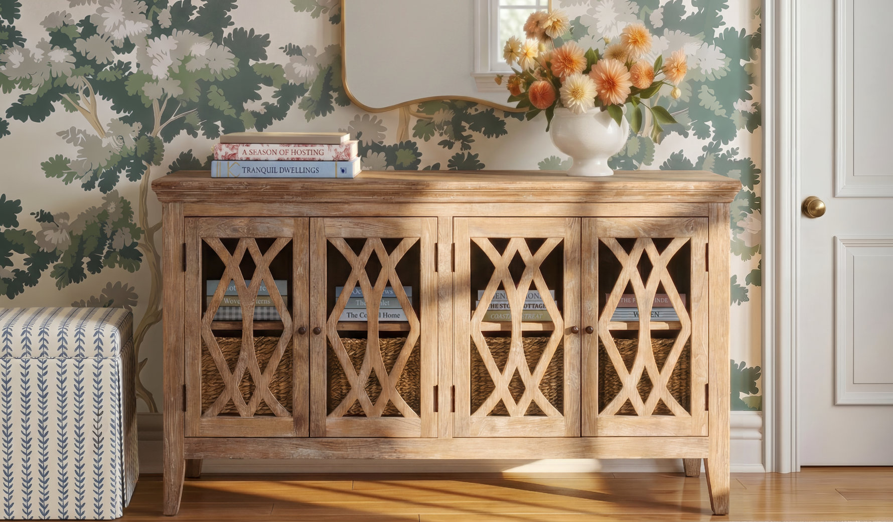Light brown wooden sideboard with four lattice-patterned cabinet doors and woven basket inserts, set against floral wallpaper with a vase of flowers and books on top.