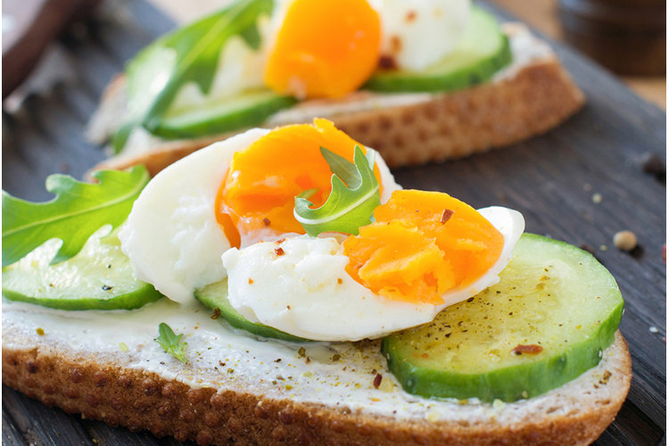 closeup of poached egg in cucumber toast