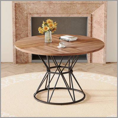Une table de salle à manger circulaire d'un diamètre de 47,3 pouces, comprenant 4 plateaux de table en bois aggloméré noyer, des supports en métal en forme de sablier noir et une table de salle à manger de style industriel moderne pour 4 à 6 personnes.