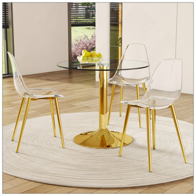 Ensemble de table et de chaises. Une table de salle à manger ronde en verre trempé transparent de 35 po - Support et base en métal doré. Assorti de 3 chaises de salle à manger en plastique transparent, de pieds en métal doré et d'un coussin de doss