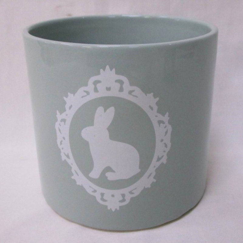 Lapin blanc dans un cadre sur un pot à fleurs bleu