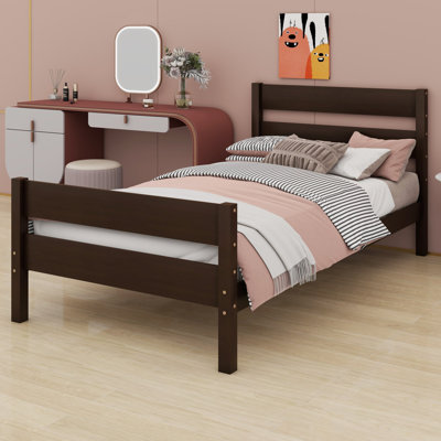 Un lit avec tête et pied de lit structure les chambres au style rustique minimaliste.