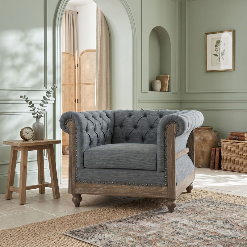Fauteuil club avec accoudoirs en volute et ornements cloutés