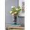 Élégant vase en verre bleu fumé avec accents chromés, présentant une silhouette de sablier et une fonctionnalité d'affichage contemporaine.