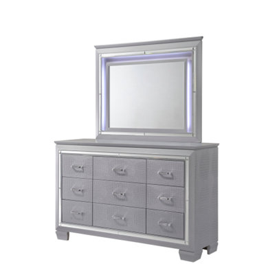 Commode moderne à neuf tiroirs avec miroir et détails chromés, finition argentée