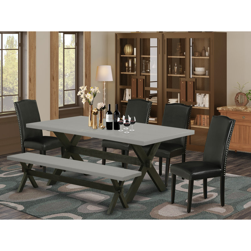 L'ensemble de table de salle à manger 6 pièces contient une table de salle à manger rectangulaire avec pieds en X et 4 chaises Parson en simili cuir noir avec banc, noir brossé
