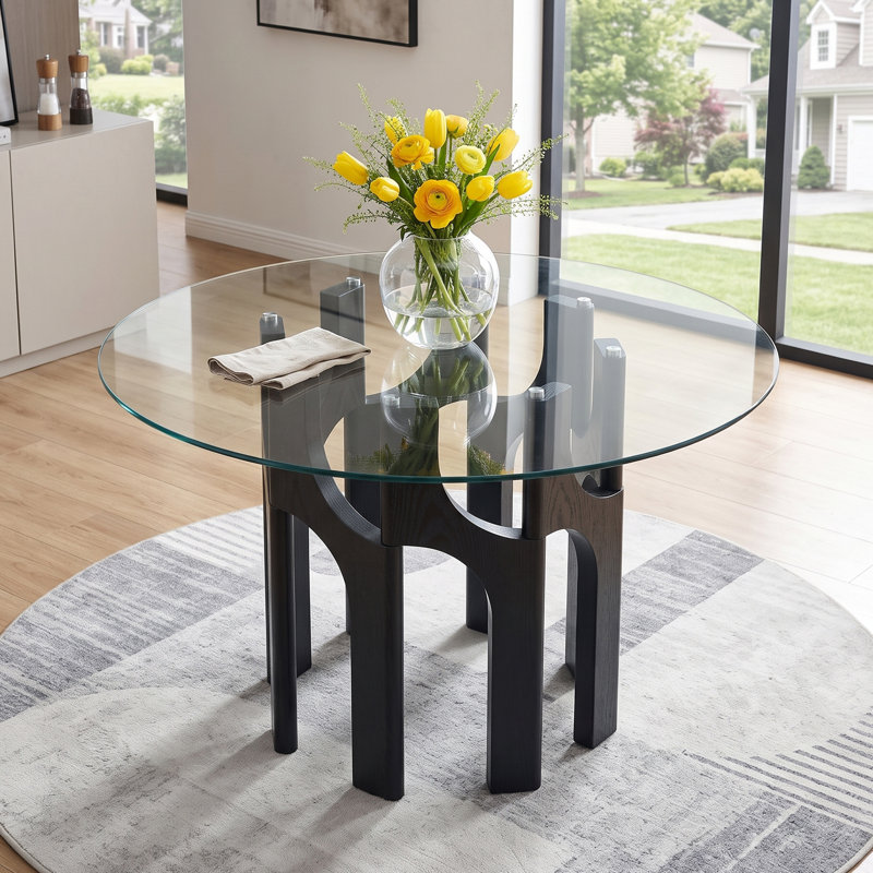 Table de salle à manger ronde de style moderne du milieu du siècle, en verre trempé de 117 cm (46 po), avec un piètement sculptural arqué en MDF à grain de bois.