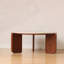 Table basse en chêne massif avec finition noyer, base sculpturale incurvée et plateau en pierre frittée blanche, table de salon moderne