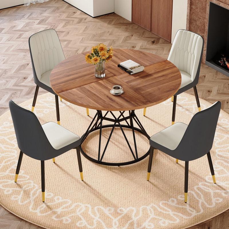 Ensemble de table et de chaises. Une table de salle à manger circulaire en panneau de fibres à densité moyenne de 47,3 po de diamètre, avec des supports en forme de sablier. Elle est assortie de 4 chaises en polyuréthane.