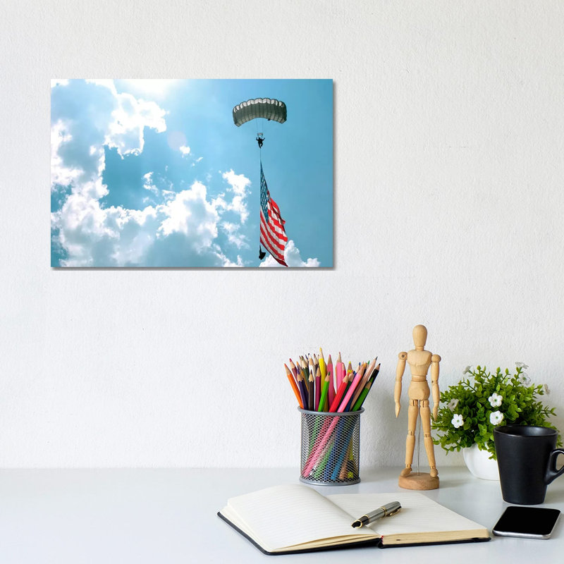 A Skydiver Carries A US Flag While Descending Through The Sky by Stocktrek Images - Wrapped Canvas Print