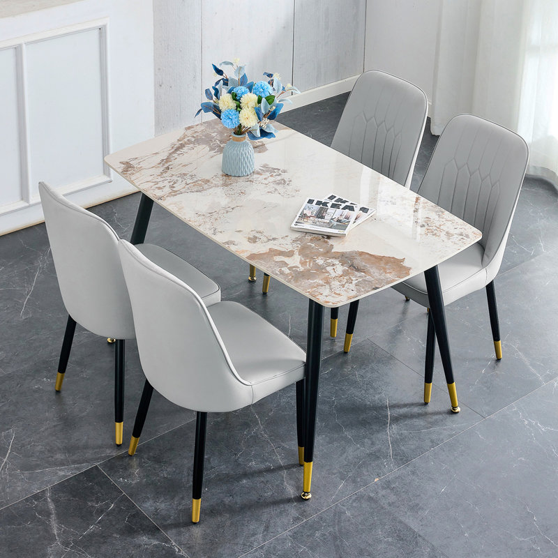 Ensemble de table et de chaises 48,4 x 28 po en pierre blanche frittée - 4 chaises gris clair avec coussins en polyuréthane et pieds en métal noir.