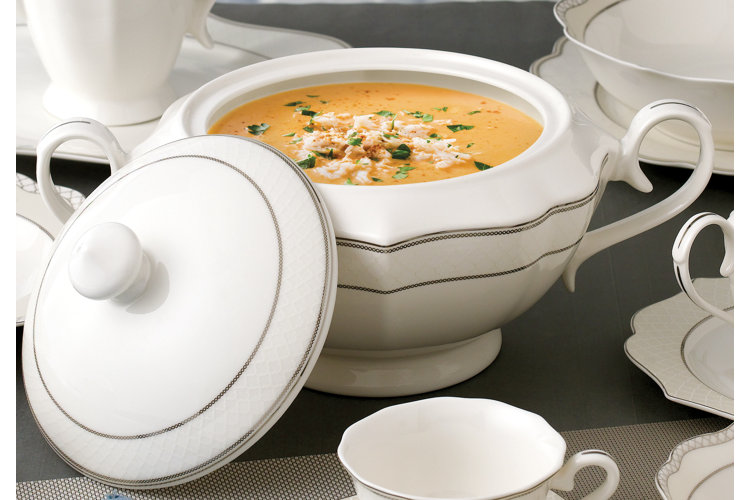 a white porcelain tureen holding butternut squash soup