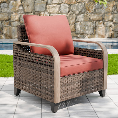 Chaise longue d'extérieur brun avec accoudoirs en osier et grain de bois avec coussin