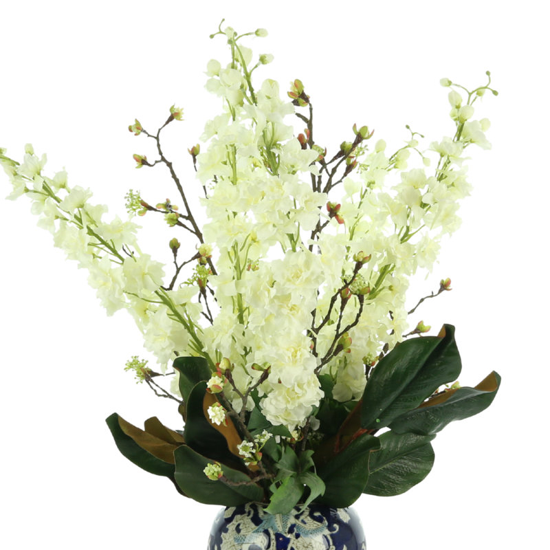 Delphinium And Magnolia Leaves In Ceramic Vase