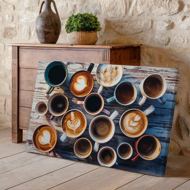 Toile vue de haut en bas d'un arrangement artistique de différentes tasses à café sur une table en bois rustique avec une variété d'art mural sur toile