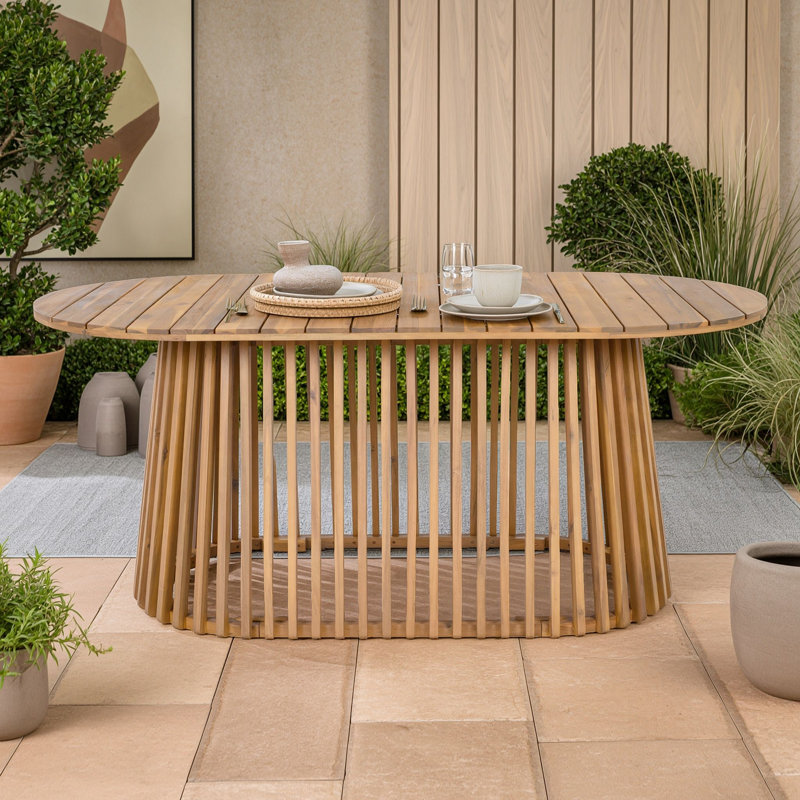 Table de salle à manger ovale d'extérieur en bois d'acacia avec base à lattes verticales fuselées, idéale pour la terrasse, le jardin, le bord de la piscine et la cour.