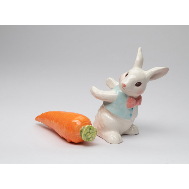 Lapin de Pâques tenant un ensemble de salière et poivrière carotte