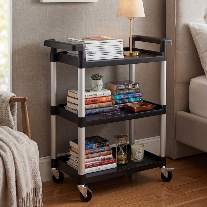 This Black Three-Layer Plastic Mobile Storage Cart Features Wheels And A Total Load Capacity Of Up To 225 Pounds. It Is Practical, Sturdy, And Made Of Black Plastic.