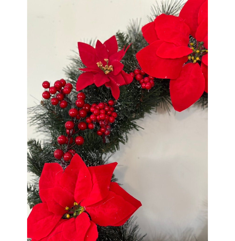 Magnifique couronne de Noël rouge à poinsettias et baies avec un magnifique nœud en velours rouge.