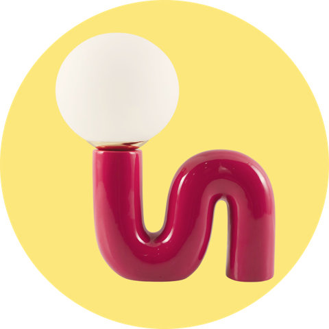 A modern accent lamp with a glossy magenta wavy base and a round white globe bulb on a yellow background.