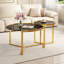 Ensemble de deux tables basses gigognes rondes au style glamour moderne, avec structure en métal doré et plateaux en verre noir.-1282441092-1282441094