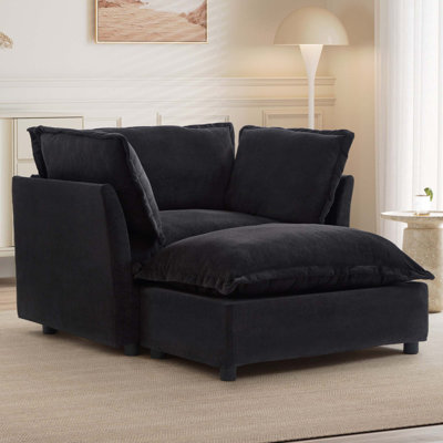 Fauteuil moderne avec repose-pieds mobile, siège large, accoudoirs courbés et coussins moelleux pour un confort douillet