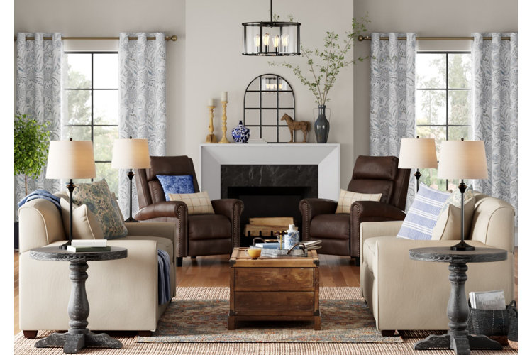 Living room with patterned curtains hanging above windows on either side of a fireplace and a pair of sofas.