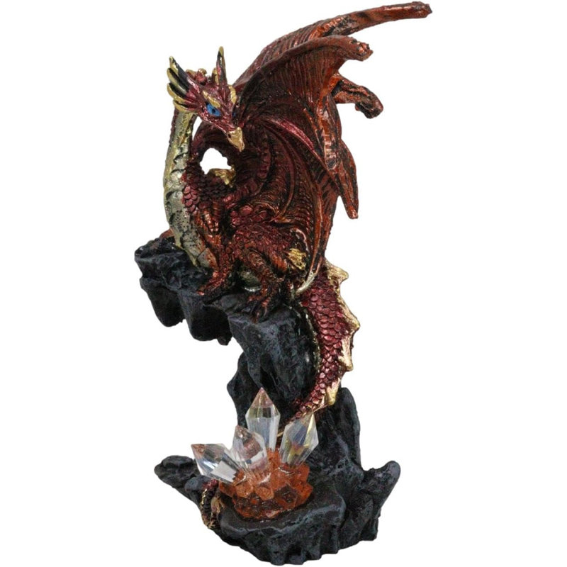 Figurine fantaisie dragon volcanique perché sur un rocher avec des cristaux