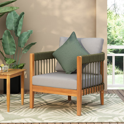 Fauteuil de jardin en bois avec des accents de corde tressée à la main sur l'assise et le dossier, forme ergonomique pour la détente, coussins imperméables. Entretien facile. Largeur : 77,5 cm, hauteur : 66 cm. Détails : confort du dossier, bas.