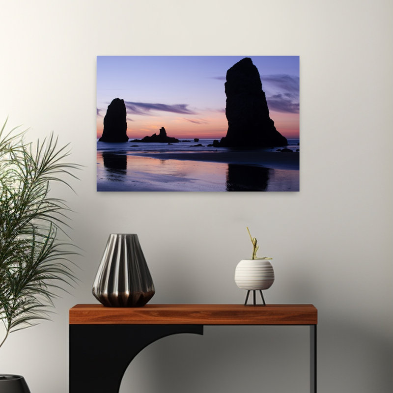 Silhouettes Of Rock Formations At Sunset At Cannon Beach Oregon USA by Dan Merkel - Wrapped Canvas Print