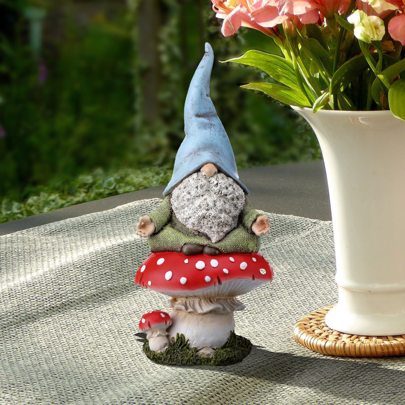 Statue gnome assis sur un champignon