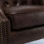 Chaise en similicuir brun classique, dossier à boutons, fauteuil élégant, finition décorative, capitonnage, dossier confortable, structure en bois franc