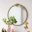 Miroir mural rond avec finition dorée et écusson décoratif