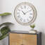 Horloge murale blanche en bois avec cadre en métal doré et détails noirs Goner