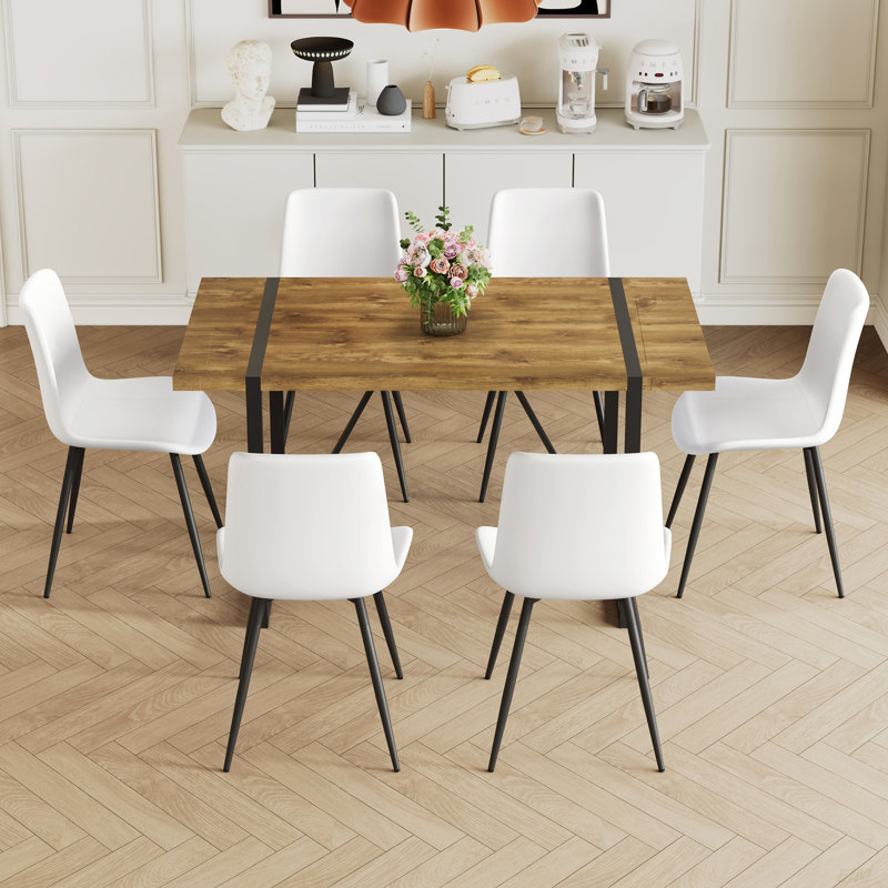 Ensemble de table et de chaises. Table de salle à manger moderne et minimaliste en bois aggloméré texturé avec structure en métal. Jumelé avec des chaises avec des coussins en suède doux et des pieds en métal noir.