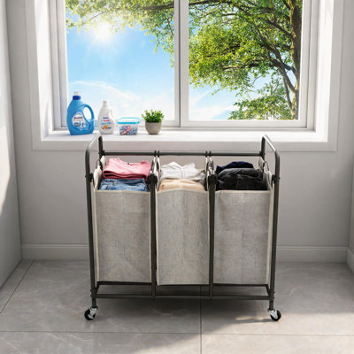 Gray Three-Compartment Metal Laundry Trolley With Locking Wheels And Detachable Fabric Storage Basket With Handle.