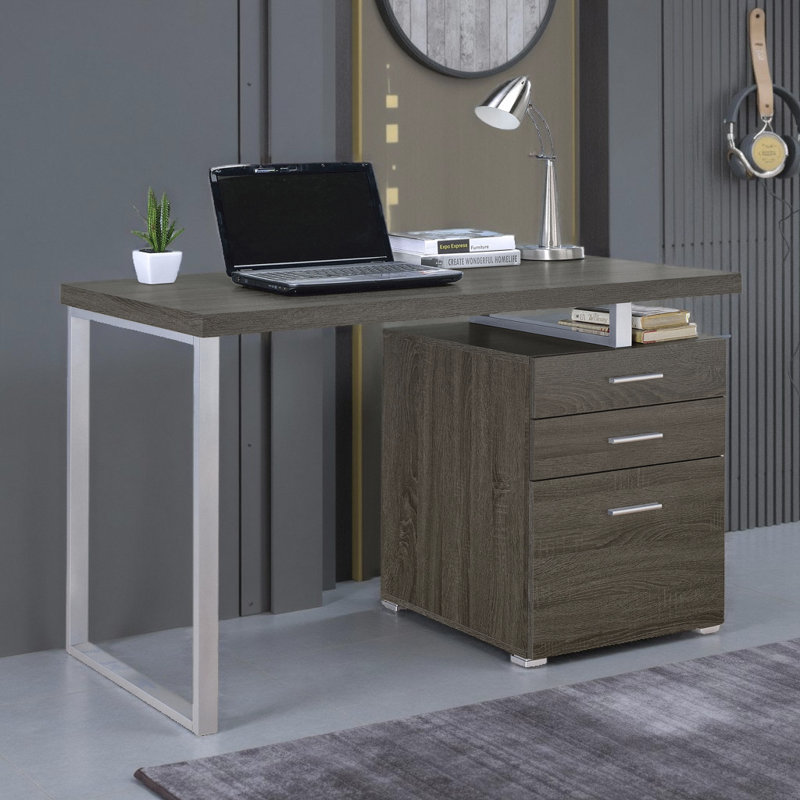 Bureau d'ordinateur moderne à 3 tiroirs réversible avec structure en métal et finition gris vieilli, idéal pour les espaces de travail flexibles.