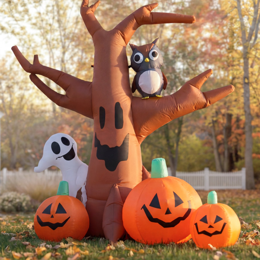 Inflatable Halloween decoration featuring a spooky tree, an owl perched on a branch, a friendly ghost, and three smiling jack-o'-lanterns on a grassy lawn.