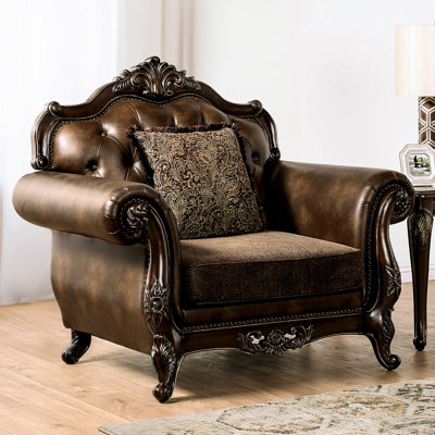 Fauteuil traditionnel aux tons cerisier foncé et marron, revêtement en tissu et cuir, accoudoirs arrondis ornés de détails, garniture cloutée, dossier capitonné, coussins d'assise style banquette, 132 cm (largeur) x 98 cm (profondeur)