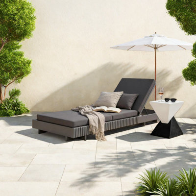 Chaise longue de patio moderne en bois gris foncé avec coussins, idéale pour les jardins ou la détente au bord de la piscine