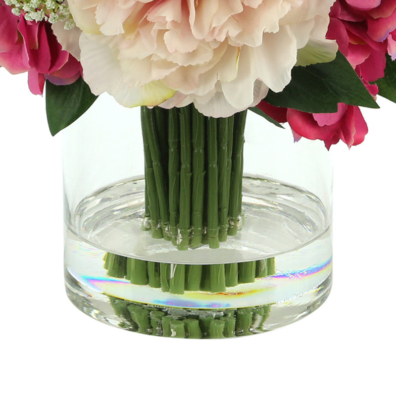 Arrangement pivoines et hortensias dans un vase en verre