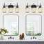 Luminaire de salle de bain moderne en cristal 3 lumières avec abat-jour en verre transparent au-dessus d'un miroir-128971903