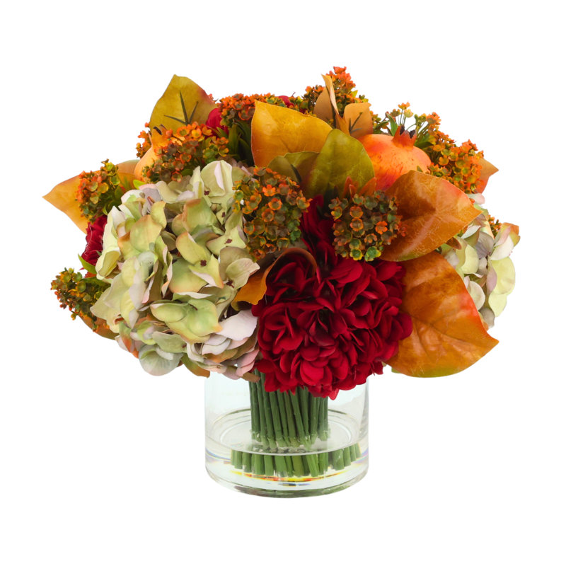 Assortiment d'hortensias et de fleurs d'automne dans un vase en verre