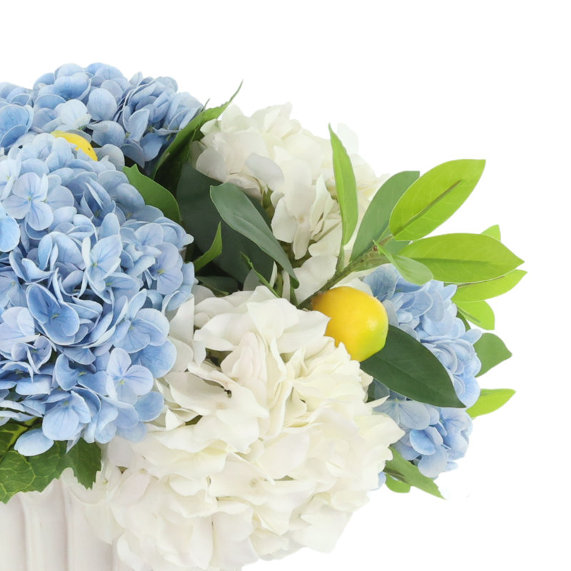 Arrangement d'hortensias et de citrons dans un vase décoratif