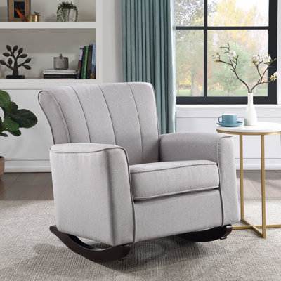 Fauteuil à bascule en lin gris, siège à ressorts ensachés, structure interne en bois, profondeur 58 cm, hauteur des accoudoirs 56 cm, poids du colis 31 kg. Fauteuil en lin, assise, dossier ferme, longueur du patin 84 cm, hauteur des accoudoirs 53 cm.