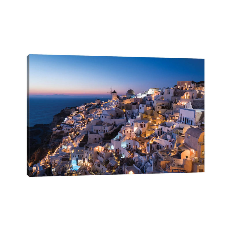 Greece, Santorini. The Village Of Oia Glows In The Post-Sunset Light As The Town'S Lights Add Magic To This Iconic Scene. by Brenda Tharp - Wrapped Canvas Print