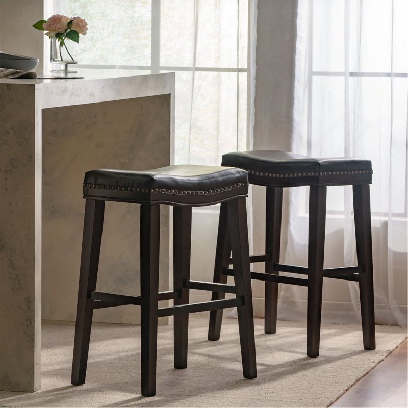 Tabouret de selle confortable avec structure en bois d'hévéa durable et cuir de polyuréthane élégant, parfait pour les cuisines modernes et les salles à manger.